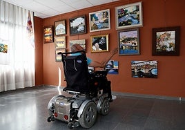 Un hombre con discapacidad observa una exposición de pinturas.