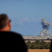 Dos personas observan una explosión en la Franja de Gaza.