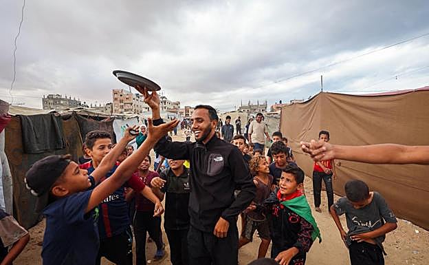 Un joven palestino reparte caramelos entre los niños del campamento de Nuseirat para festejar el alto el fuego.