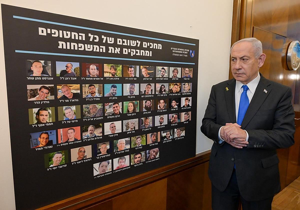 Benjamín Netanyahu observa el panel con las fotos de los rehenes aún sin liberar de camino a la sesión del Consejo de Seguridad israelí.