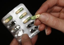 Un hombre extrae un fármaco antidepresivo de su envoltorio.