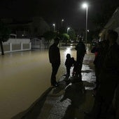 Vecinos de Los Alcázares, de madrugada, en una calle inundada.