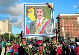 Un hombre esgrime un retrato de Maduro durante un ejercicio militar para responder a un ataque externo.