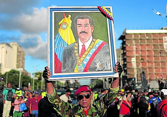 Un hombre esgrime un retrato de Maduro durante un ejercicio militar para responder a un ataque externo.