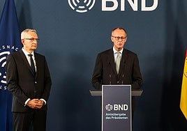 Martin Jäger escucha al canciller alemán Friedrich Merz en un discurso en la agencia de Inteligencia.