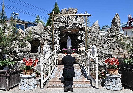 Una mujer reza frente a una iglesia católica en el norte de China.