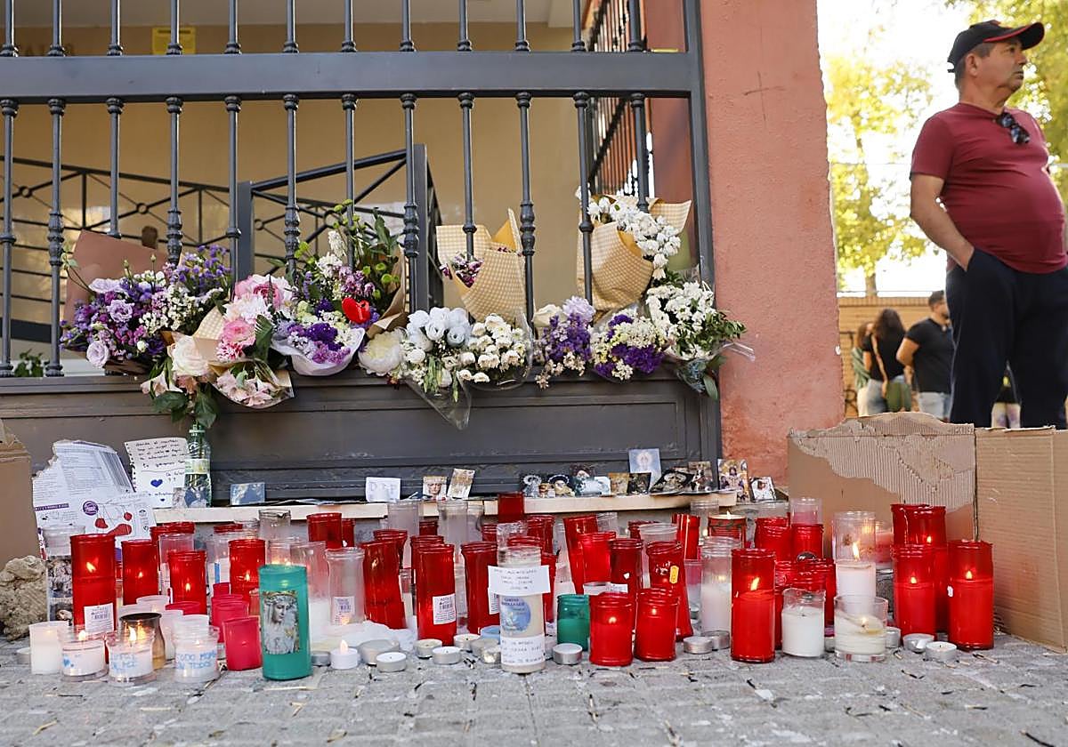 Un pequeño altar improvisado ante la vivienda de Sandra, la joven que se suicidó el pasado martes en Sevilla.