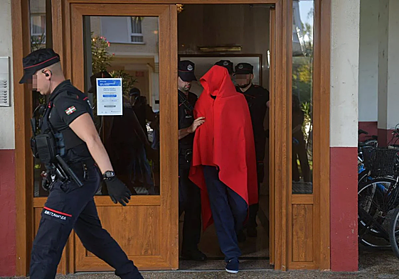El detenido ha salido de la vivienda acompañado de varios agentes de la Ertzaintza y cubriendo su rostro con una manta roja.
