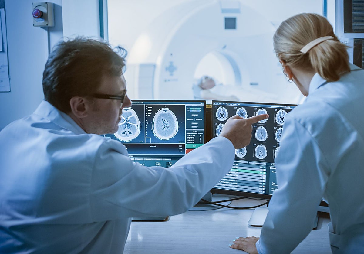 Dos médicos especialistas en cáncer observan resultados de un paciente.