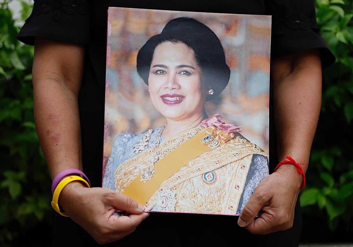 Una mujer sostiene un retrato de la reina emérita tailandesa en Bangkok.