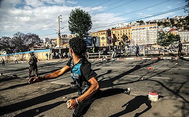 Un manifestante lanza una piedra a miembros de las fuerzas de seguridad durante una manifestación antigubernamental en Madagascar.