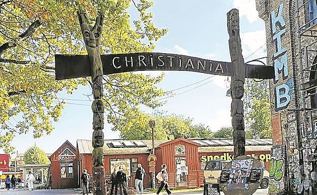 Un cartel de madera anuncia la entrada al barrio.