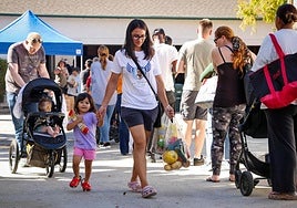 Grupos de familias hacen cola para recibir donativos de alimentos en San Diego, California.