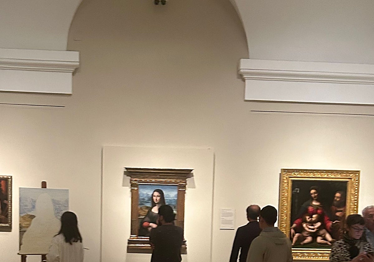 Visitantes observan la 'Mona Lisa' del Prado mientras una pintora, a la izquierda, realiza una copia de la copia.