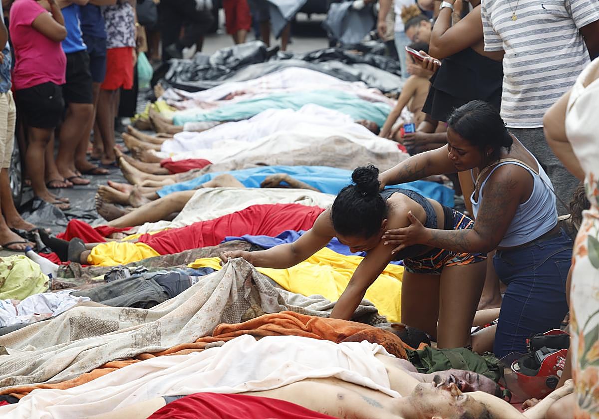 Familiares y vecinos, junto a los muertos acumulados en la plaza de Sao Lucas.
