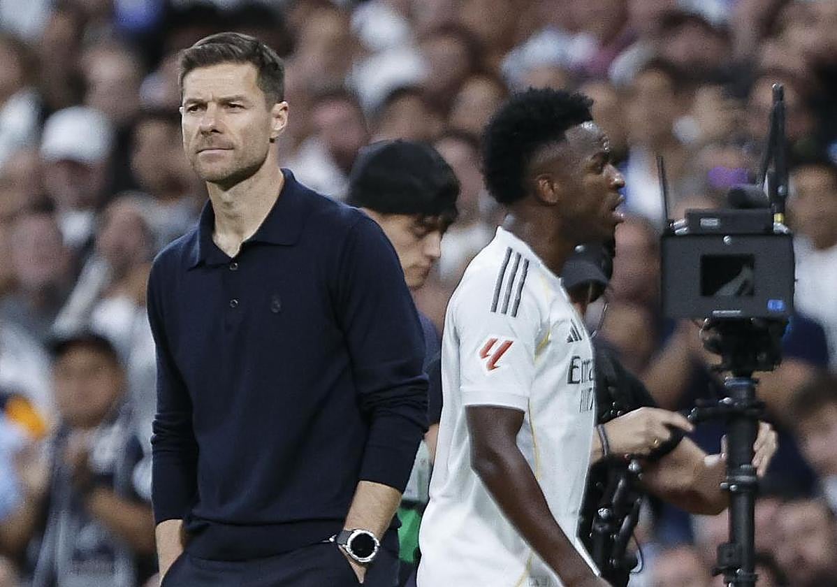 Vinicius pasa junto a Xabi Alonso tras ser sustituido en el clásico.