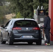 Un hombre repostando en una gasolinera.