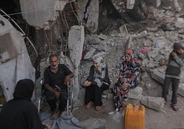 Familias palestinas viven entre los escombros de torres residenciales destruidas por ataques aéreos israelíes en Gaza.