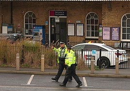 Agentes de policía caminan fuera de la estación de Huntingdon.