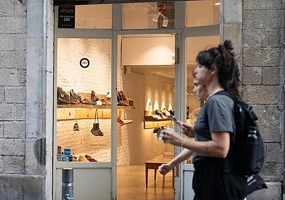 Dos jóvenes pasan al lado de una zapatería.