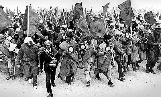 Manifestantes marroquíes en la Marcha Verde portan el Corán y retratos del rey Hassan II el 6 de noviembre de 1975.