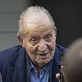 El rey emérito saluda ayer desde un coche tras aterrizar en el aeropuerto vigués de Peinador.