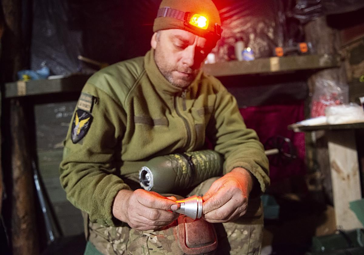 Imagen principal - Soldados ucranianos preparan drones para la guerra.