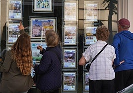 Varias personas mirando anuncios de viviendas.