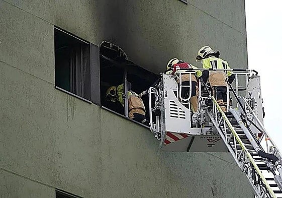 Bomberos entran en el edificio incendiado.
