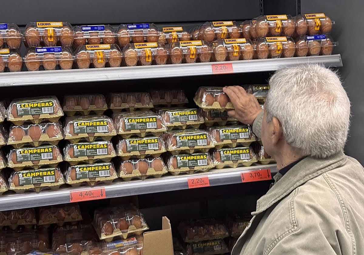 Un hombre compra huevos en un supermercado.