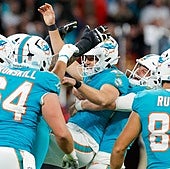 Los jugadores de los Dolphins celebran con patterson la victoria.