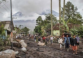 Residentes locales se trasladan a lugares seguros tras la erupción del volcán Semeru.