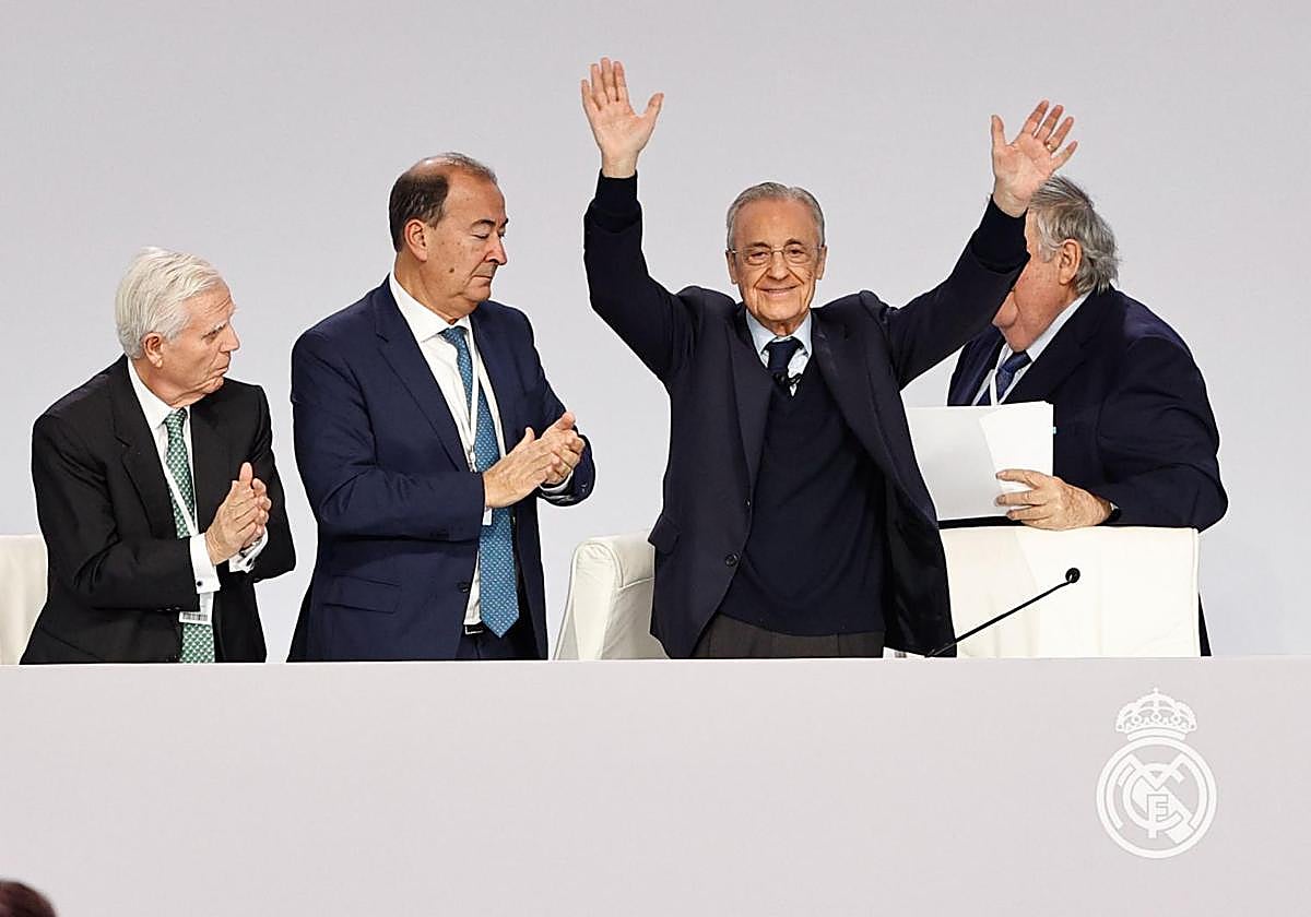 Florentino Pérez levanta los brazos y es aplaudido por sus directivos tras su discurso en la asamblea del Real Madrid.