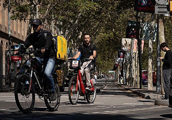 Dos personas circulan con bicicleta eléctrica por Barcelona