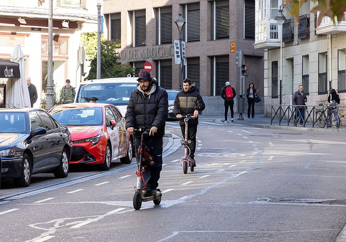 Dos patinetes eléctricos circulan por la calle Angustias de Valladolid.