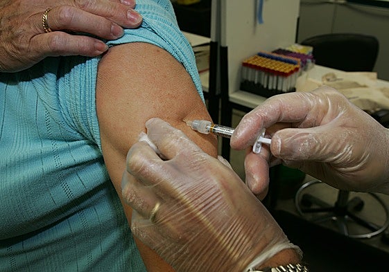 Una mujer recibe una dosis de la vacuna contra la gripe.