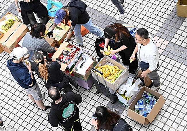 Varios voluntarios reparten comida entre los afectados.