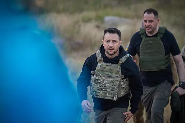 Yermak camina detrás de Zelenski en una visita al frente.