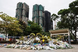 Ramos de flores en homenaje a las víctimas del incendio de las torres de Hong Kong.