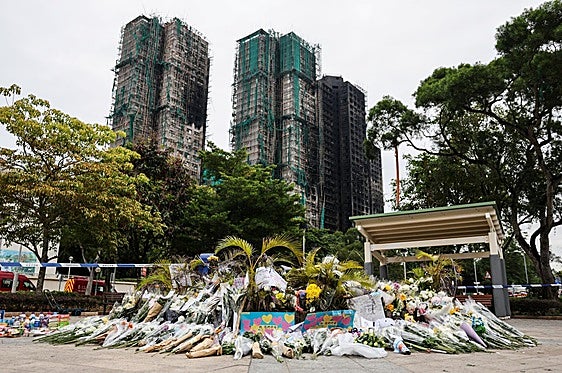 Ramos de flores en homenaje a las víctimas del incendio de las torres de Hong Kong.