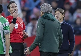 Munuea Montero comunica a los técnicos la interrupción del derbi sevillano por incidentes de público.