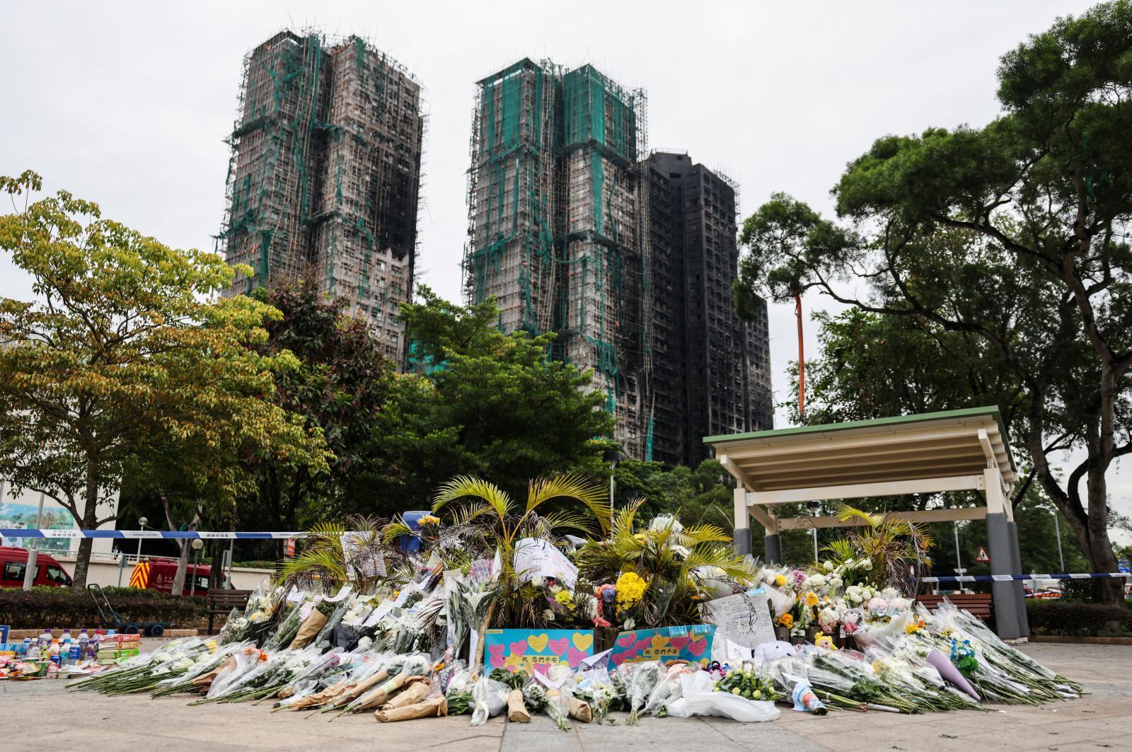 Ramos de flores en homenaje a las víctimas del incendio de las torres de Hong Kong.