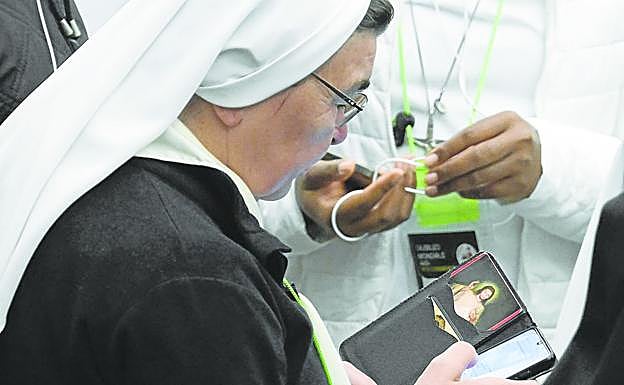 Una monja consulta su teléfono móvil mientras asiste a una reunión durante el Jubileo.