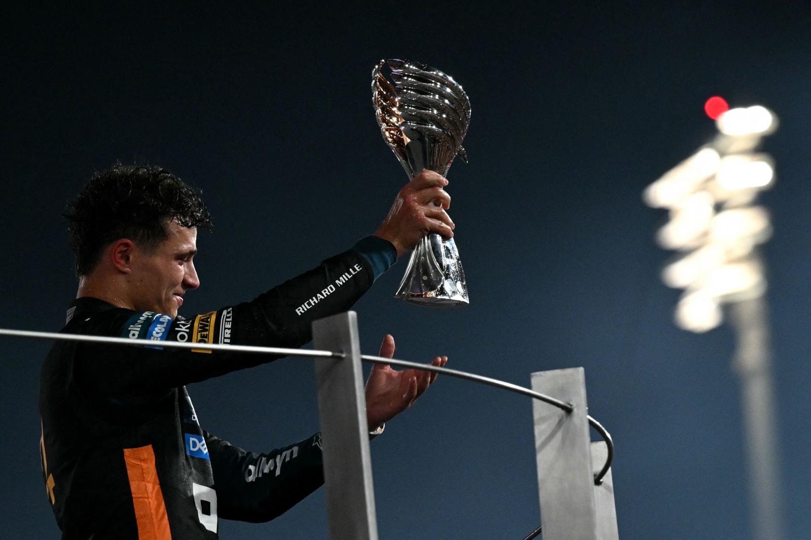 Lando Norris, muestra el trofeo como tercer clasificado en el GP de Abu Dabi que le ha valido apra ser camepón del mundo..