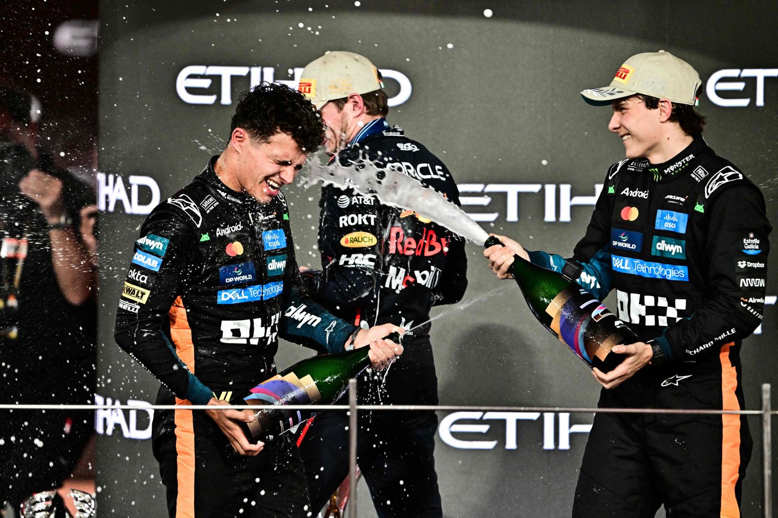 Oscar Piastri, compañero de Lando Norris en McLaren, baña en champagne al nuevo campeón del mundo.