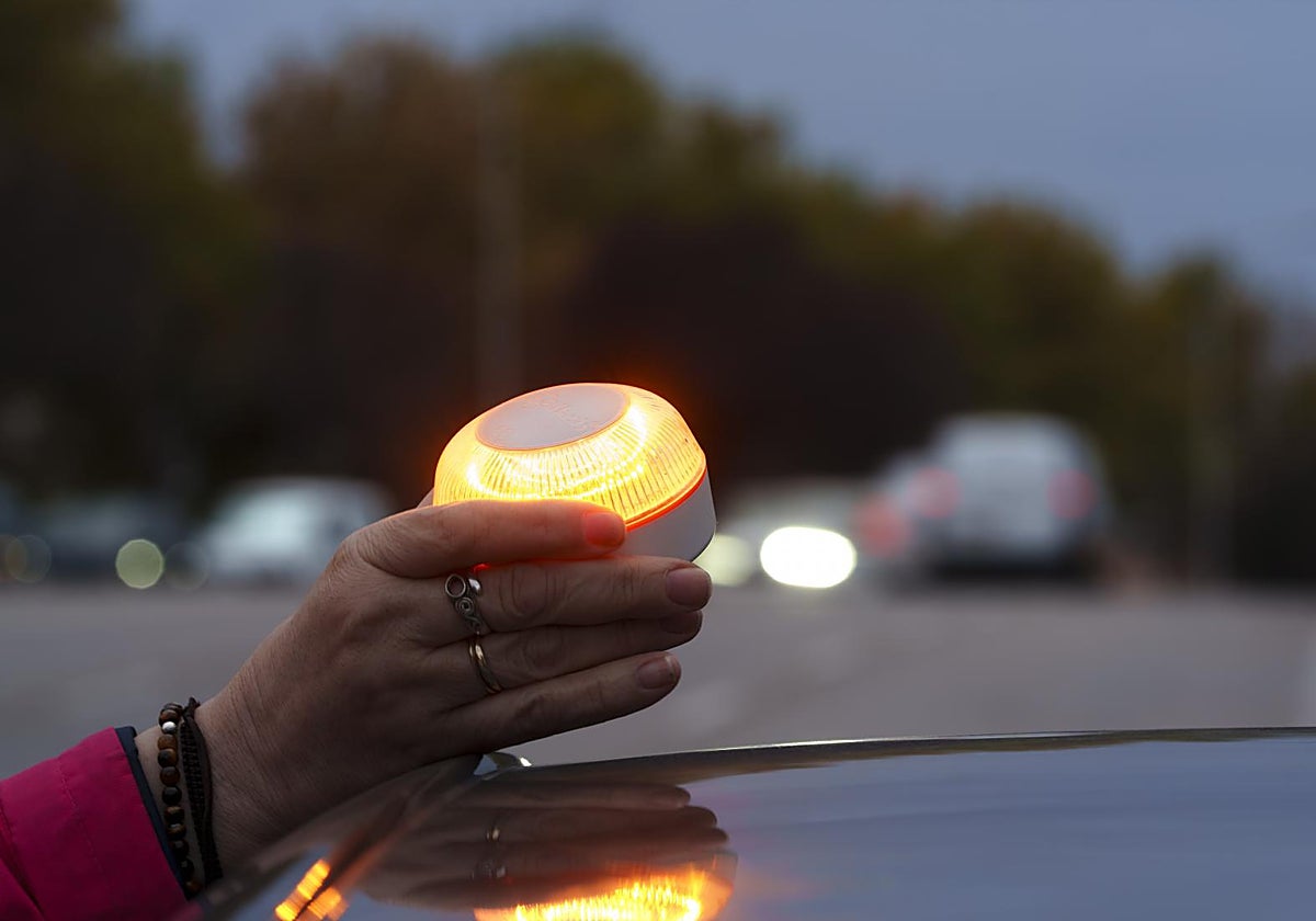 Una conductora coloca una baliza V-16 sobre su coche.