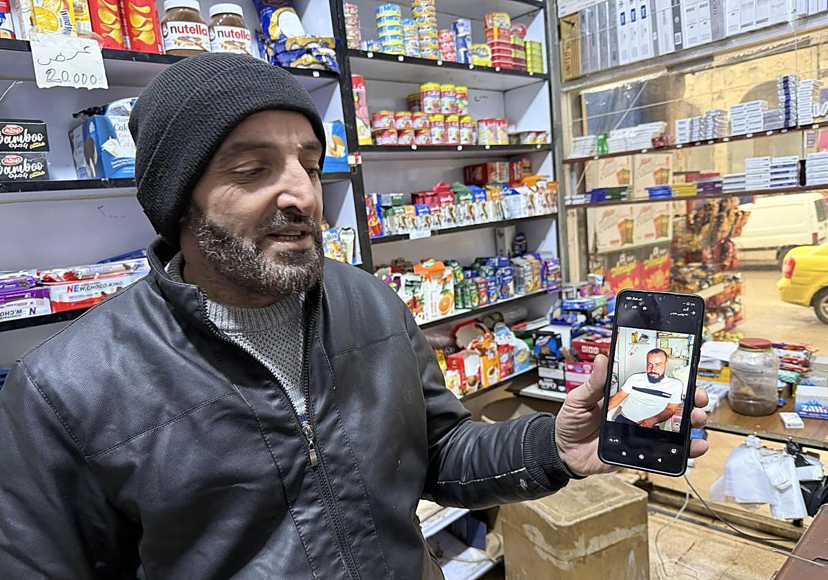 Imagen principal - Farez Mohamed Mayaza, antiguo preso de Sednaya, regenta ahora una tienda de ultramarinos en Duma; entrada a la cárcel. 