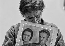 Una vecina desalojada abraza una foto de sus padres.