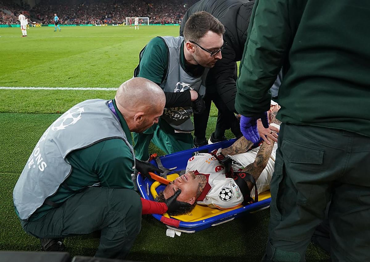 İkincil resim 1 - Yukarıdaki resimde Noa Lang olaydan sonra oksijen alıyor. Aşağıda, solda, futbolcu bir sedye üzerinde taşınıyor. Sağda, Liverpool personeli kesintinin meydana geldiği çitleri inceliyor.