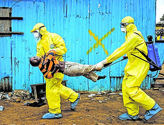Personal médico traslada a un niño de ocho años, sospechoso de tener ébola, a un centro de tratamiento en Monrovia, Liberia.